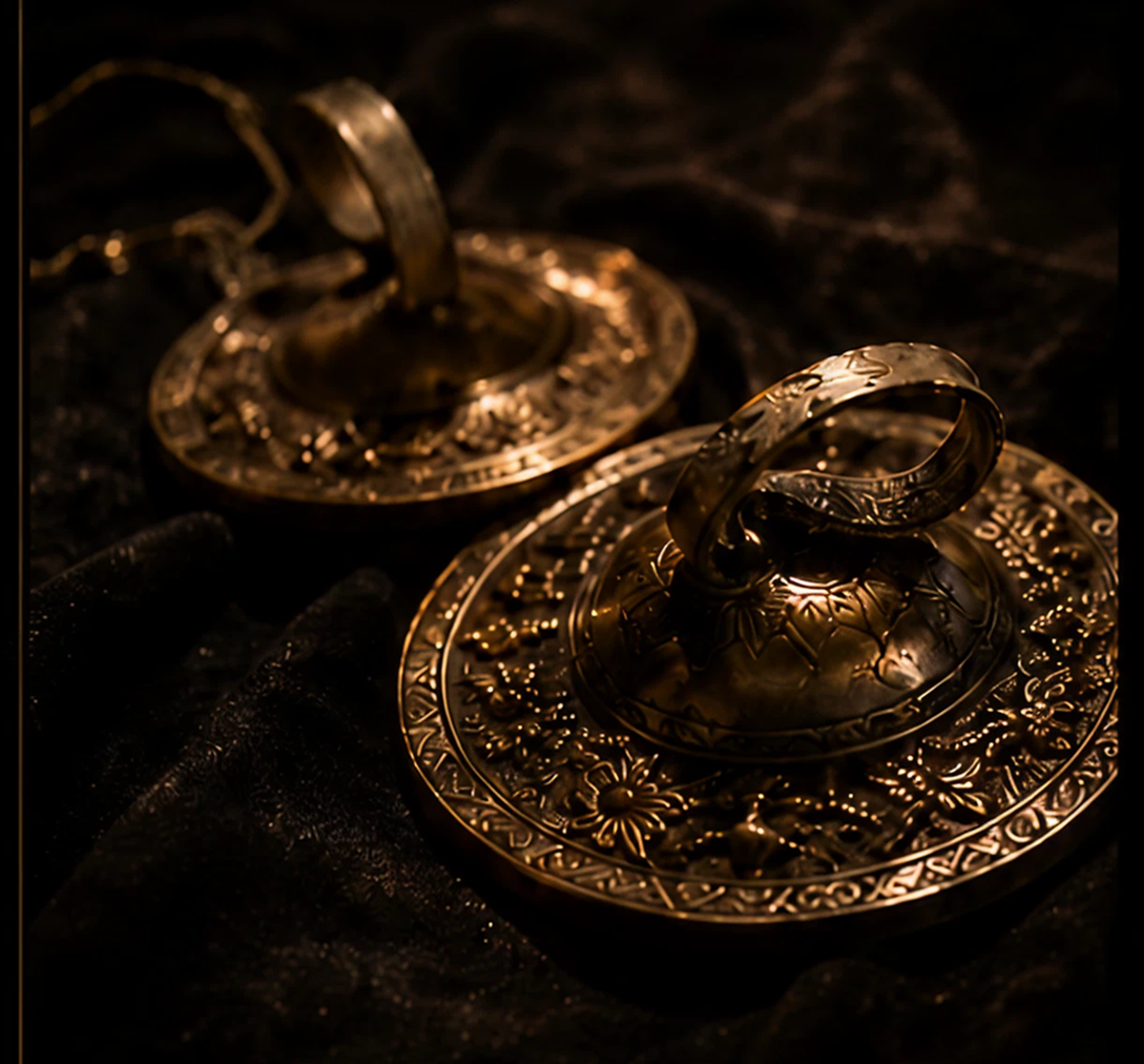 Ornate bronze cymbals on dark fabric.